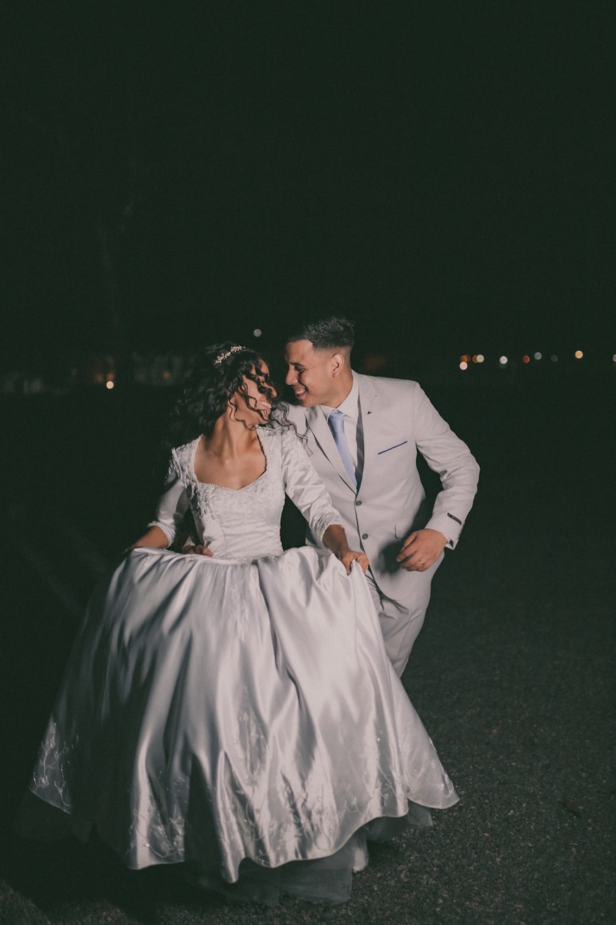 A bride carried across the lawn at dusk, guests laughing